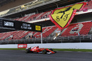 Sebastian Vettel speeds past the giant Ferrari flag