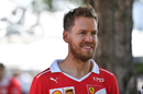 Sebastian Vettel arrives the paddock with a smile on his face