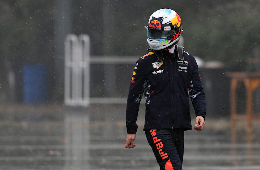 Daniel Ricciardo walks through the paddock with his helmet