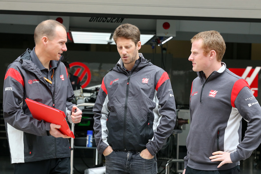 Romain Grosjean talks with engineers at the garage