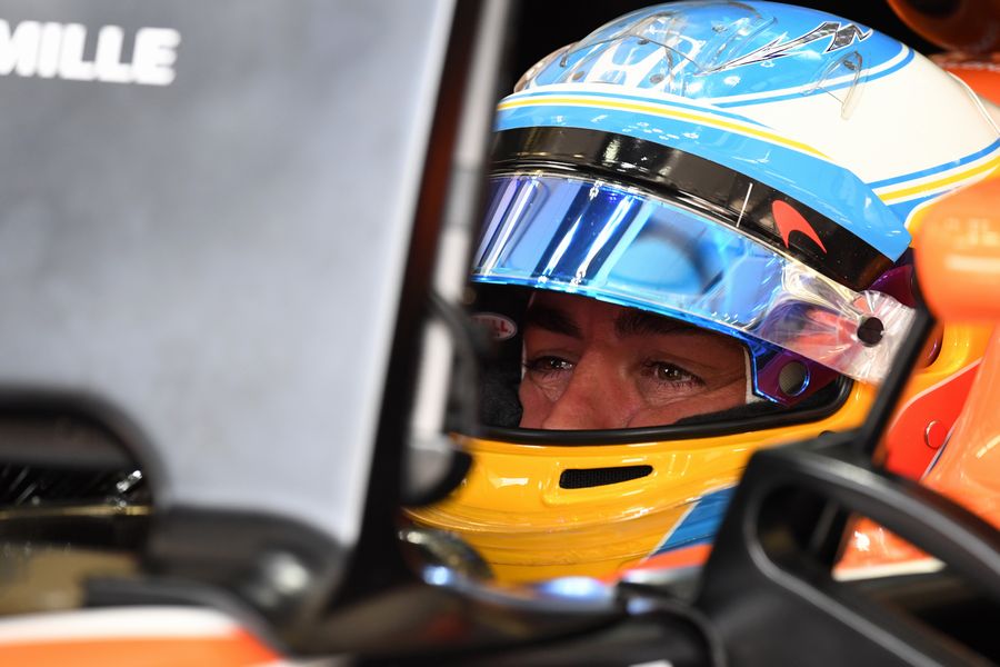 Fernando Alonso sits in the McLaren cockpit in the garage

