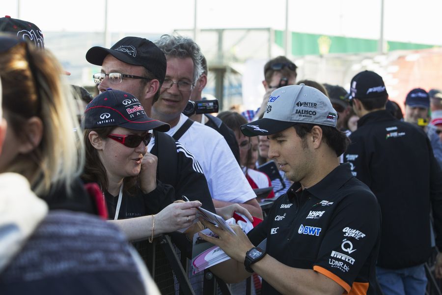 Sergio Perez signs an autograph for a fan