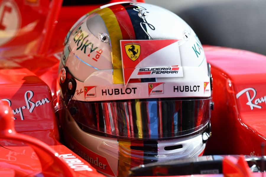 Sebastian Vettel sits in the Ferrari cockpit in the garage