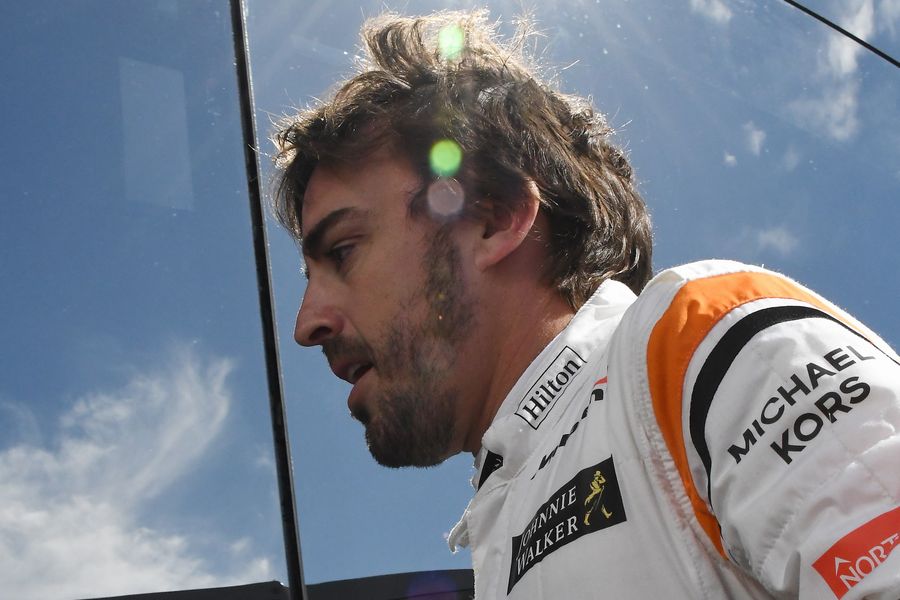 Fernando Alonso walks in after stopping on track in FP1