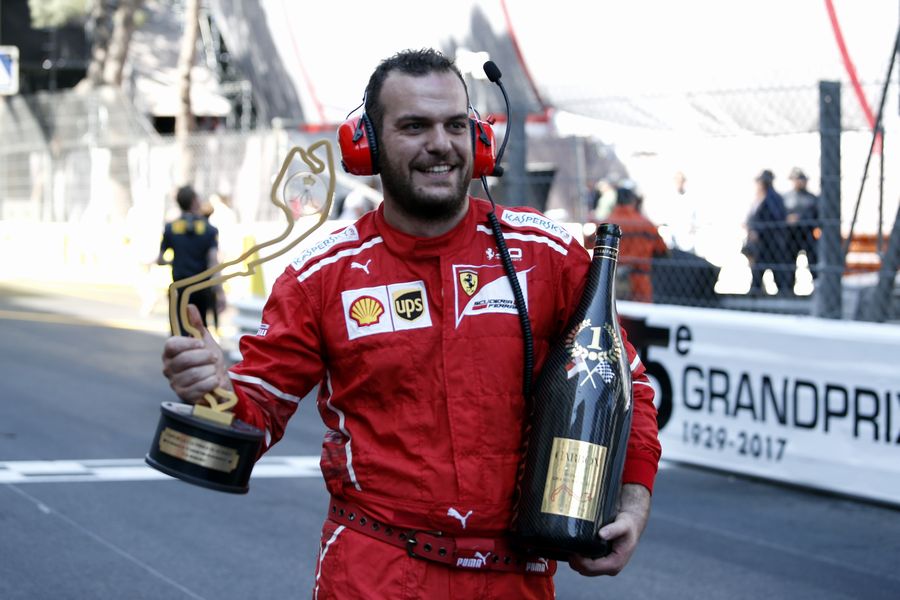 Ferrari mechanic celebrates with the trophy and the champagne on the parc ferme
