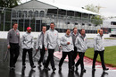Lewis Hamilton walks a wet circuit with his race engineers