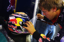 Sebastian Vettel applies a visor tear-off to his helmet