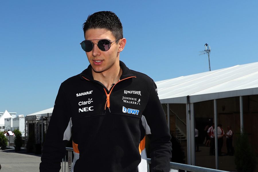 Esteban Ocon walks through the paddock