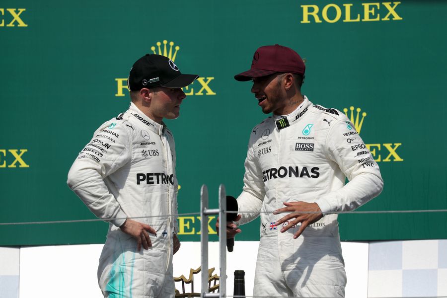 Race winner Lewis Hamilton celebrates on the podium with Valtteri Bottas
