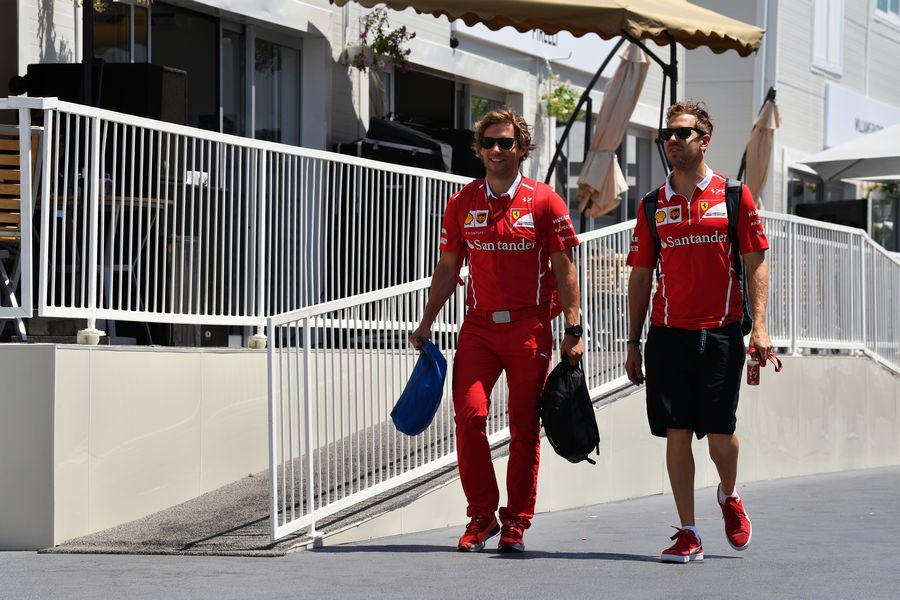 Sebastian Vettel walks the paddock with his trainer Antti Kontsas