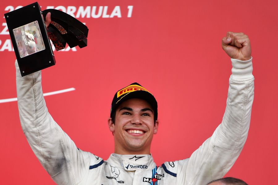 Lance Stroll celebrates on the podium with the trophy