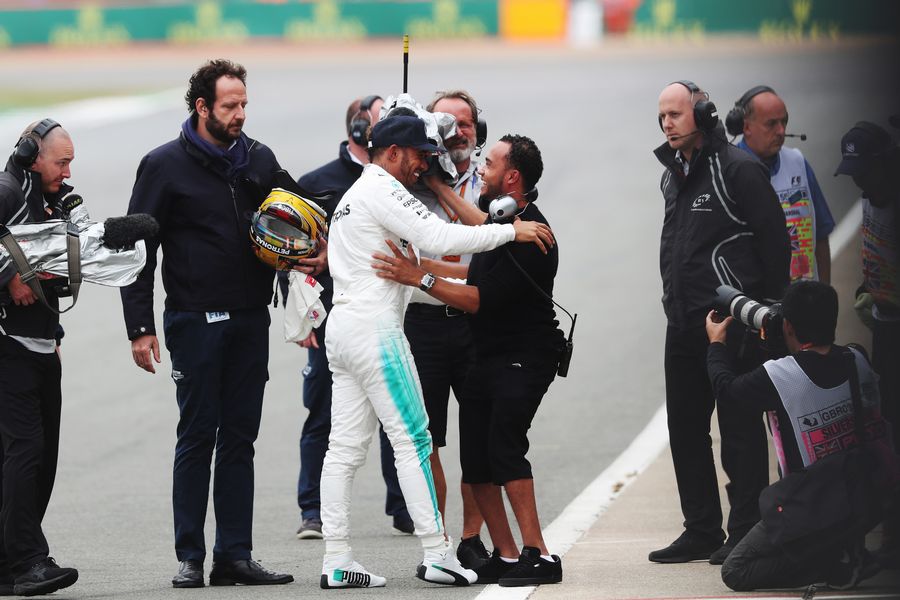 Pole sitter Lewis Hamilton celebrates with his brother Nick Hamilton in parc ferme