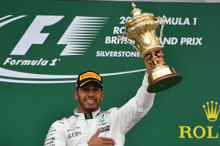 Lewis Hamilton celebrates on the podium with the trophy Formula 1