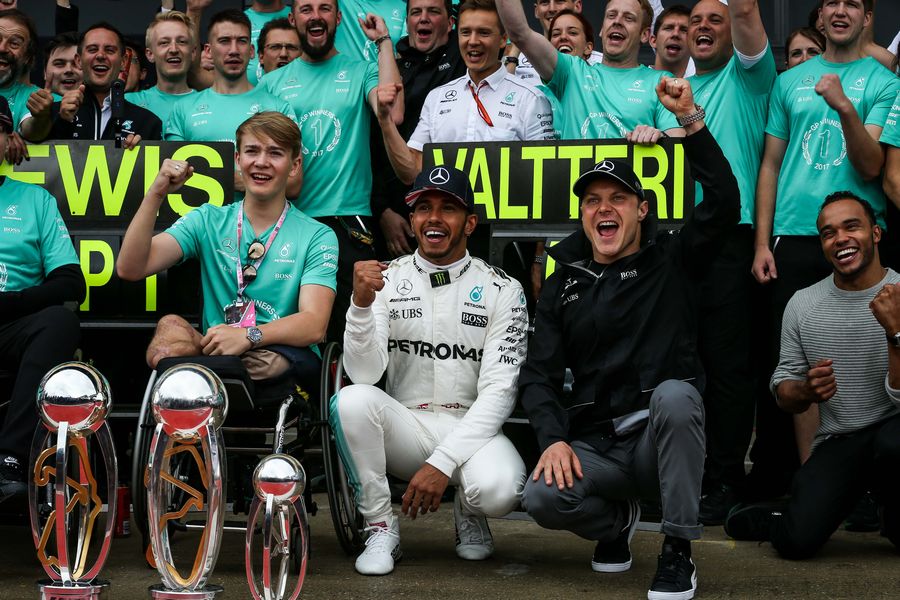 Lewis Hamilton celebrates with his trophies alongside Valtteri Bottas, his brother Nick Hamilton, Billy Monger and the team