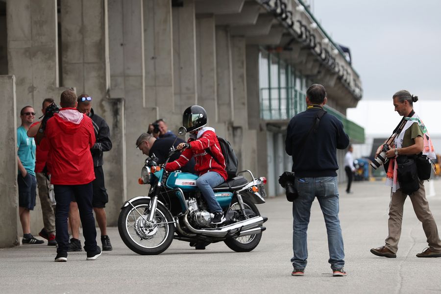 Sebastian Vettel arrives on a Suzuki 750 motor bike