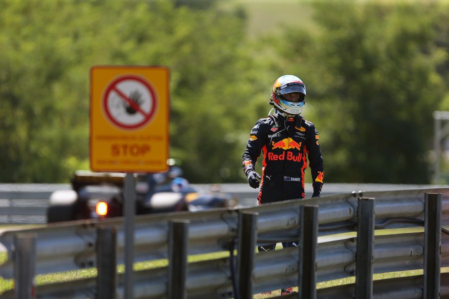 Daniel Ricciardo walks on track after stopping on track in FP3