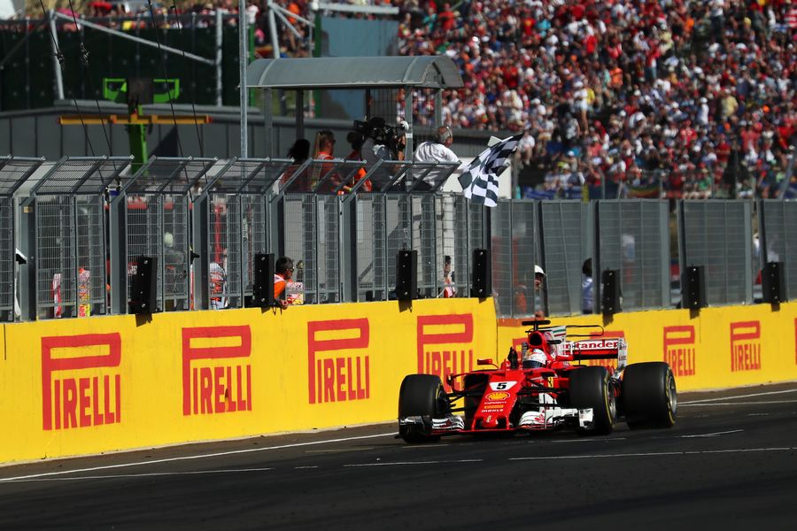 Race winner Sebastian Vettel takes the chequered flag