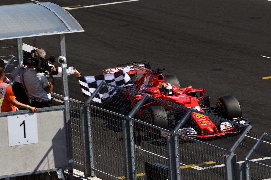 Race winner Sebastian Vettel takes the chequered flag