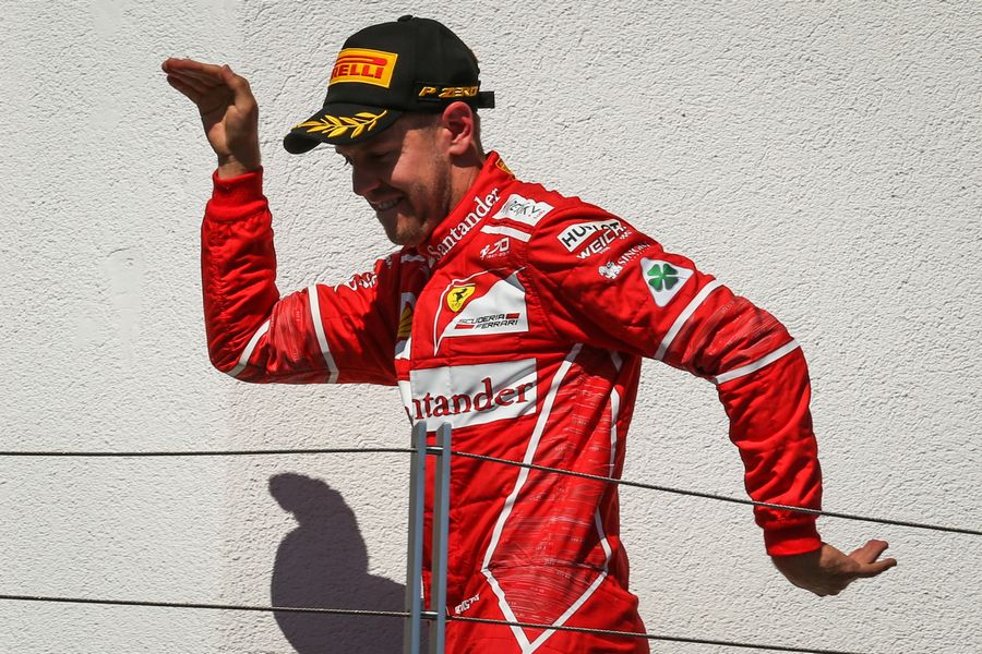 Race winner Sebastian Vettel celebrates on the podium