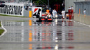 Lewis Hamilton attempts to push his McLaren back to the pits after running out of fuel