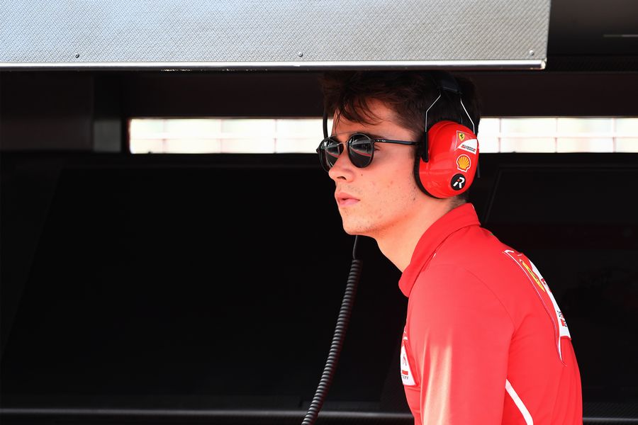 Charles Leclerc stands on the pit wall