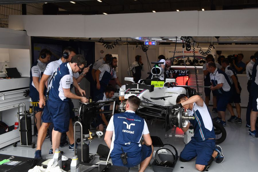 Mechanics work on the car of Felipe Massa in the garage