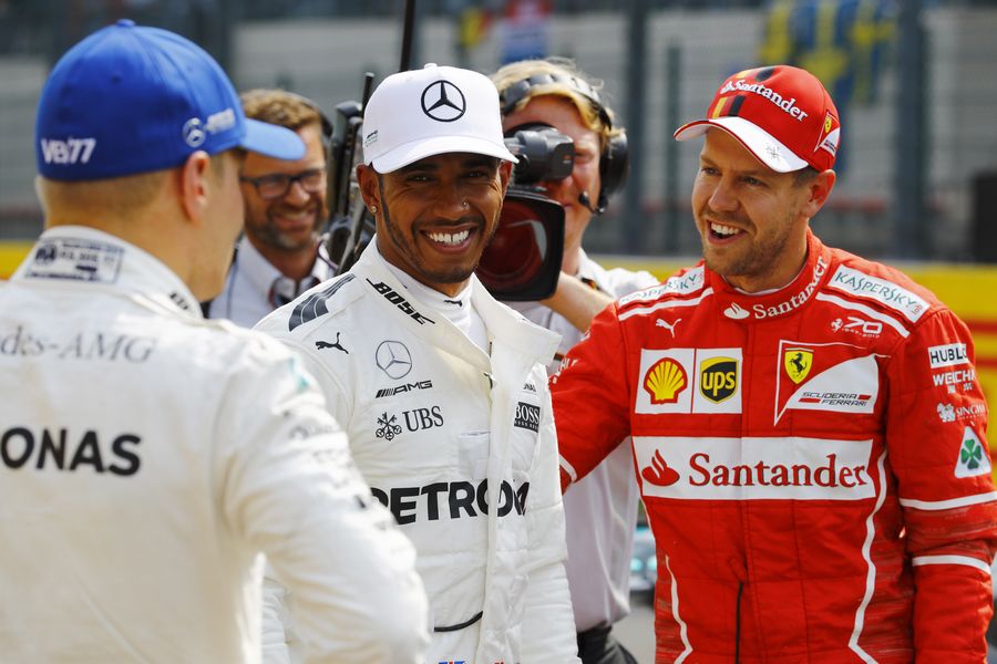Pole sitter Lewis Hamilton celebrates in parc ferme with Sebastian Vettel and Valtteri Bottas