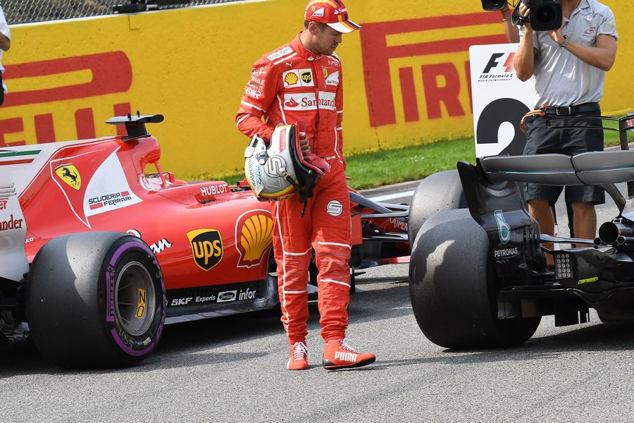 Sebastian Vettel celebrates and observes the car of Lewis Hamilton in parc ferme