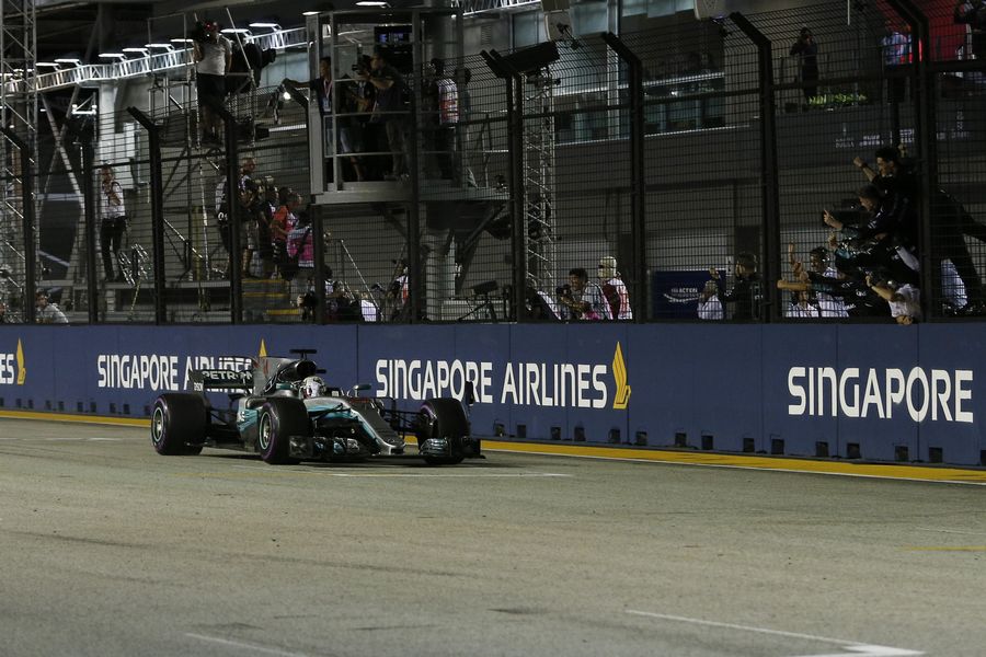 Race winner Lewis Hamilton crosses the line