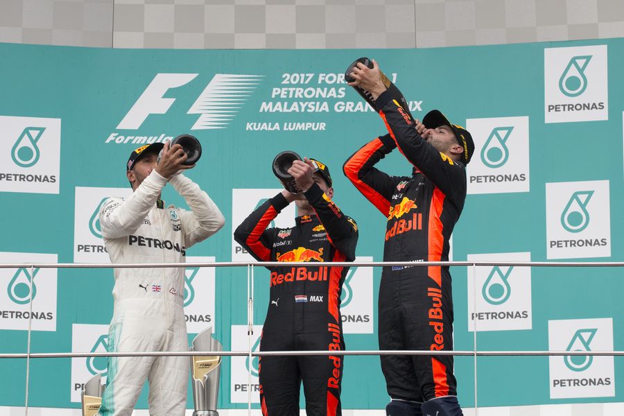 Race winner Max Verstappen, Lewis Hamilton and Daniel Ricciardo celebrate on the podium with the champagne