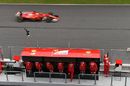Sebastian Vettel passes the Ferrari pit wall gantry