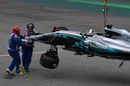 The crashed car of Lewis Hamilton is recovered in Q1
