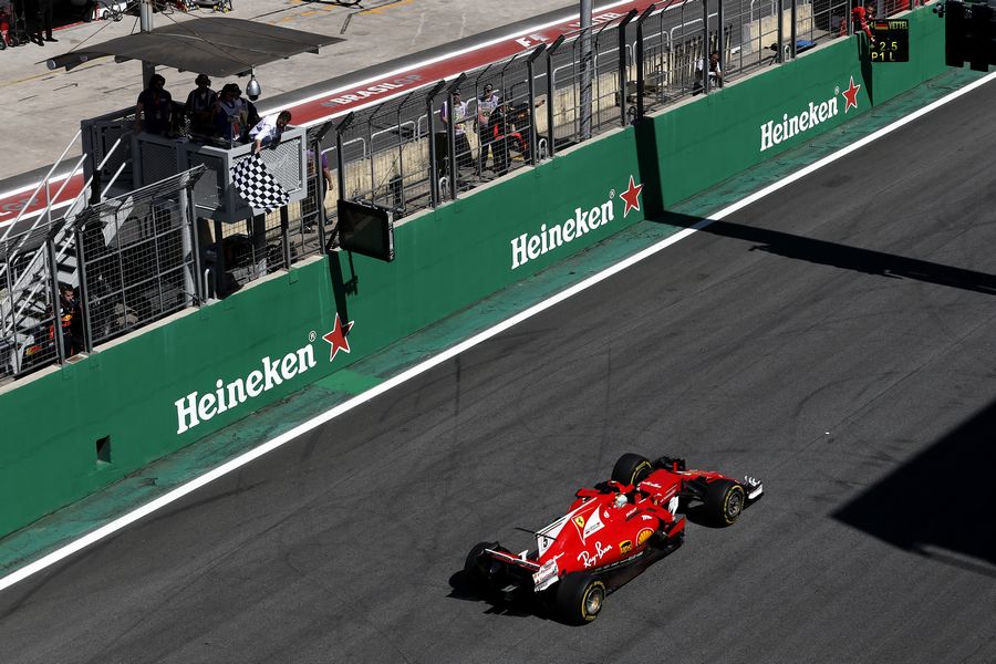 Race winner Sebastian Vettel crosses the line to take the chequered flag and win the race