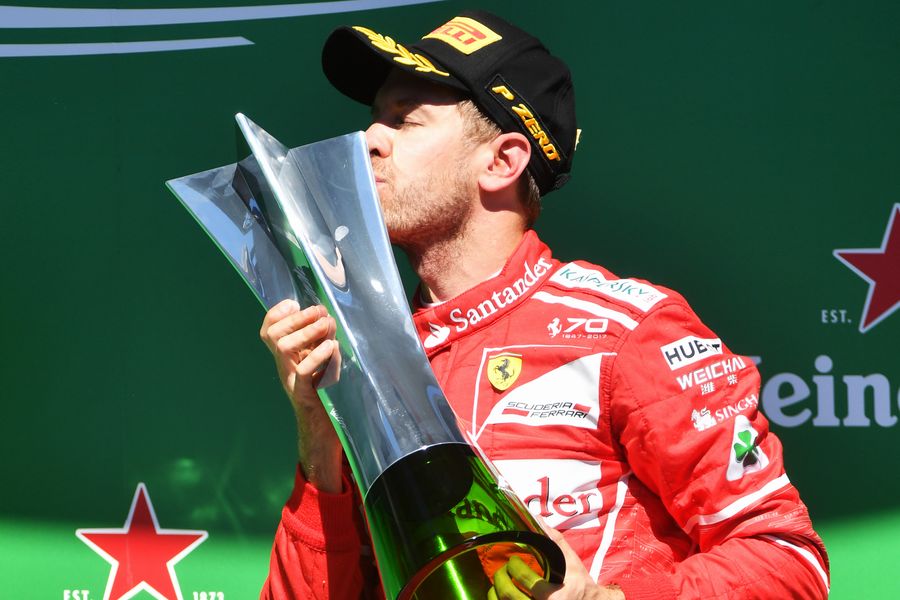 Race winner Sebastian Vettel celebrates on the podium with the trophy