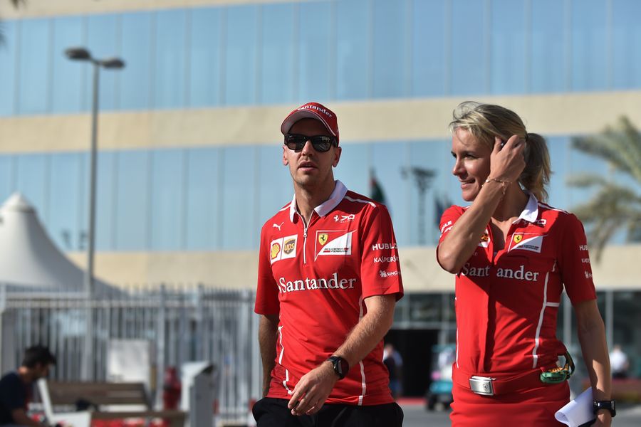 Sebastian Vettel walks through the paddock with his PA Britta Roeske