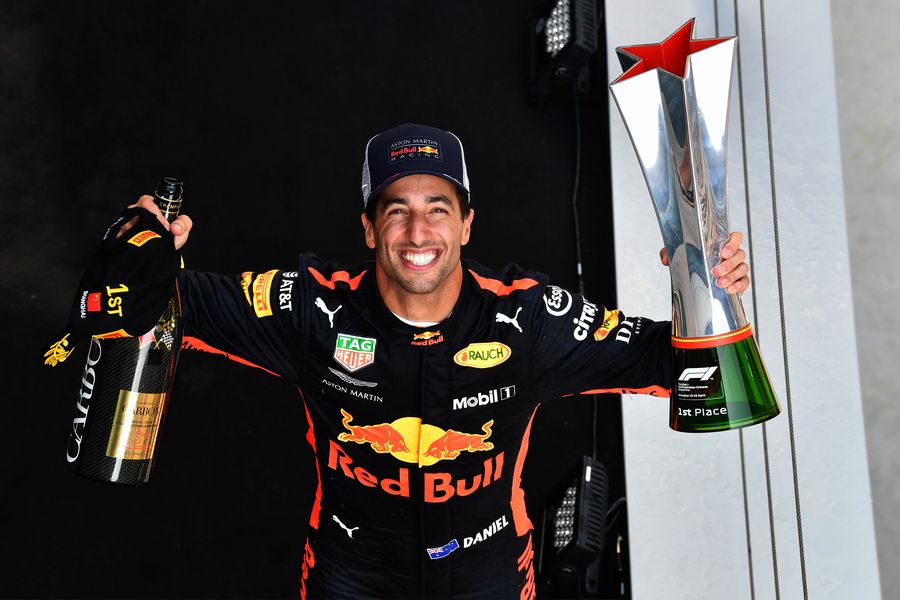 Race winner Daniel Ricciardo celebrates on the podium with the trophy