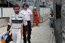 Fernando Alonso returns to the pits after Race retired
