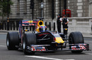 Police watch on as Mark Webber drives through the streets of London