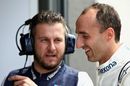 Robert Kubica talks with a Williams team member in the garage