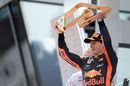 Race winner Max Verstappen celebrates on the podium with the trophy