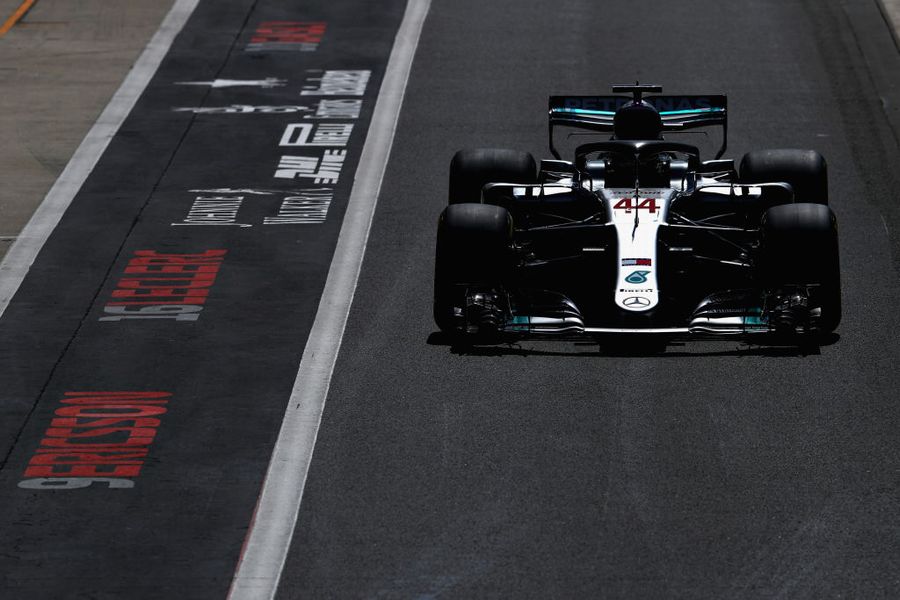 Lewis Hamilton powers down the pit lane in the Mercedes