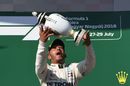 Race winner Lewis Hamilton celebrates on the podium with the trophy