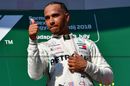 Race winner Lewis Hamilton gives the thumb up as he celebrates on the podium