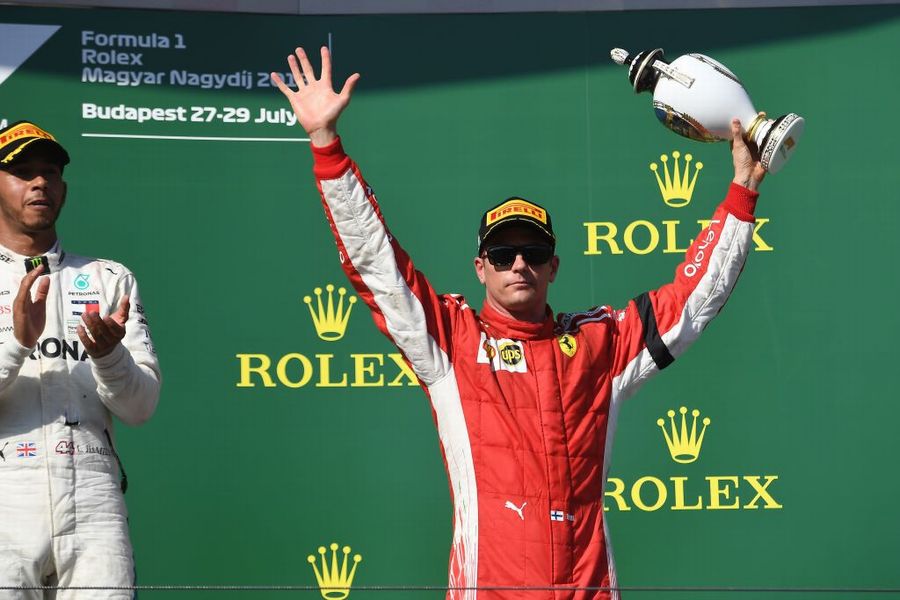 Kimi Raikkonen celebrates on the podium with the trophy