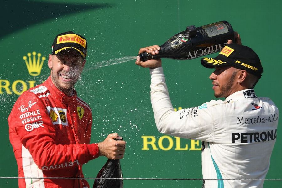 Race winner Lewis Hamilton and Sebastian Vettel celebrate on the podium with the champagne