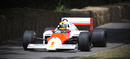 Lewis Hamilton gives a thumbs up in a 1986 McLaren-TAG MP4/2C 