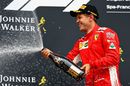Race winner Sebastian Vettel celebrates on the podium with the champagne