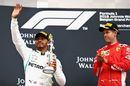 Lewis Hamilton celebrates on the podium as race winner Sebastian Vettel
