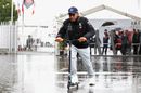 Lewis Hamilton arrives at the circuit on the scooter in the rain
