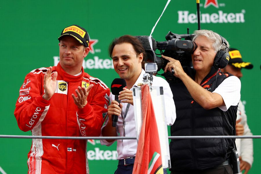 Kimi Raikkonen speaks with Felipe Massa on the podium